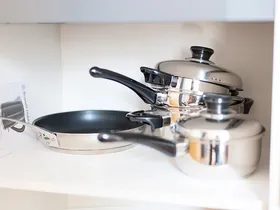 Töpfe und Pfanne im Küchenschrank
