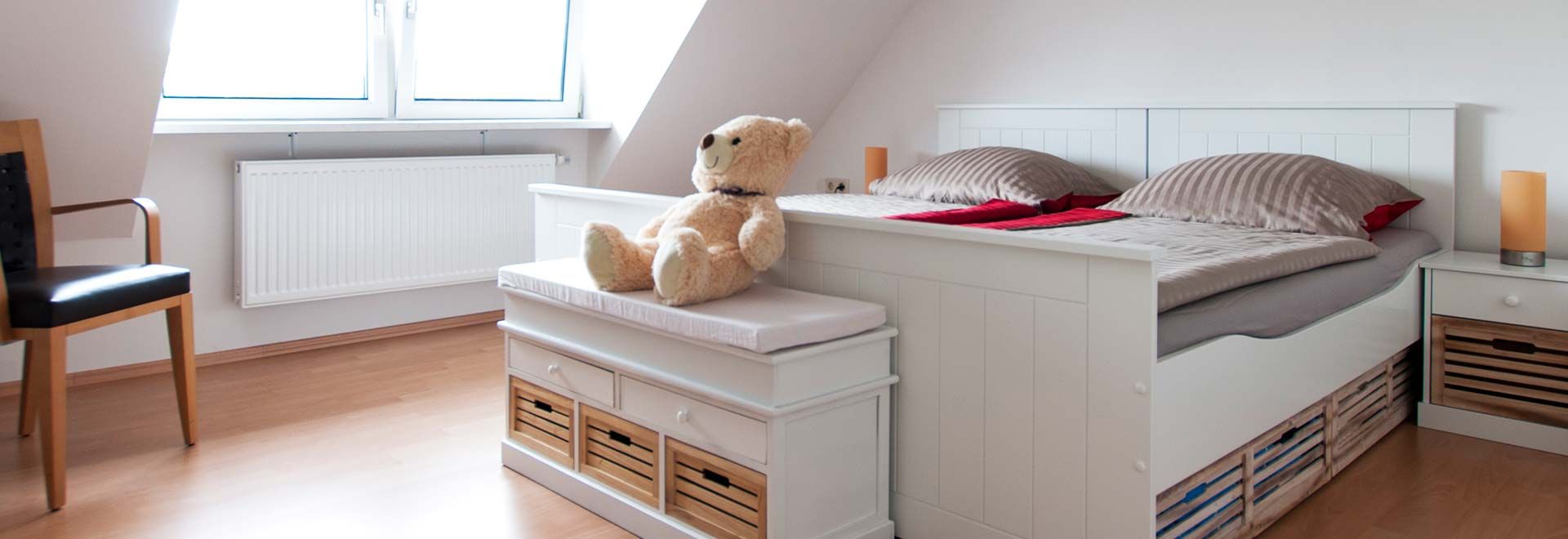 Gästezimmer mit Teddybär und Bett in der Altstadtpension Salzwedel