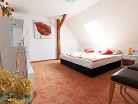 Doppelzimmer mit Dachfenster und Holzbalken